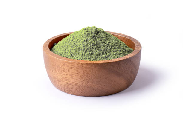 Matcha green tea powder in wooden bowl isolated on white background.